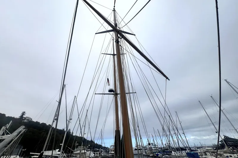 Slide: The Image of Tall mast of 1934 Pankey Schooner in a marina, surrounded by other sailboats. - 13