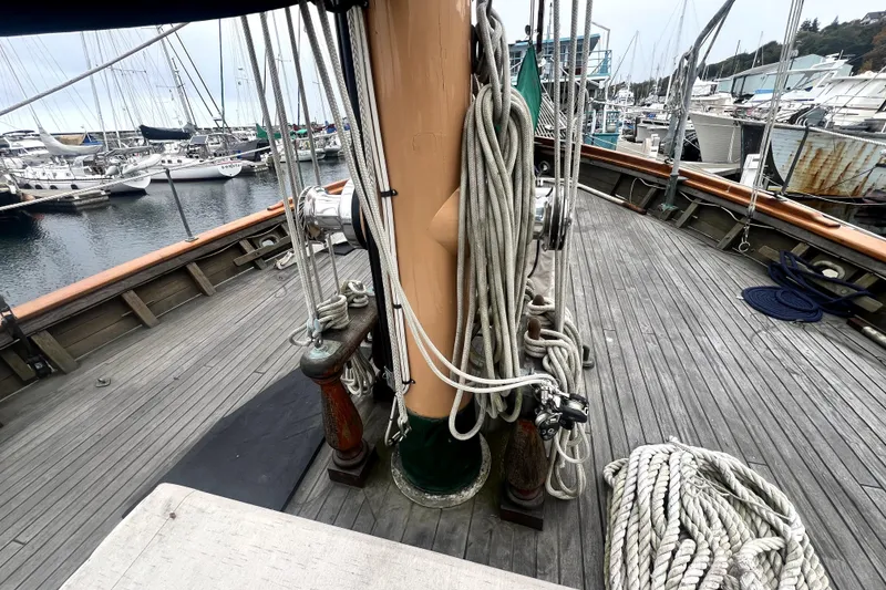 Slide: The Image of Deck view of a 1934 Pankey Schooner with ropes and marina background. - 17