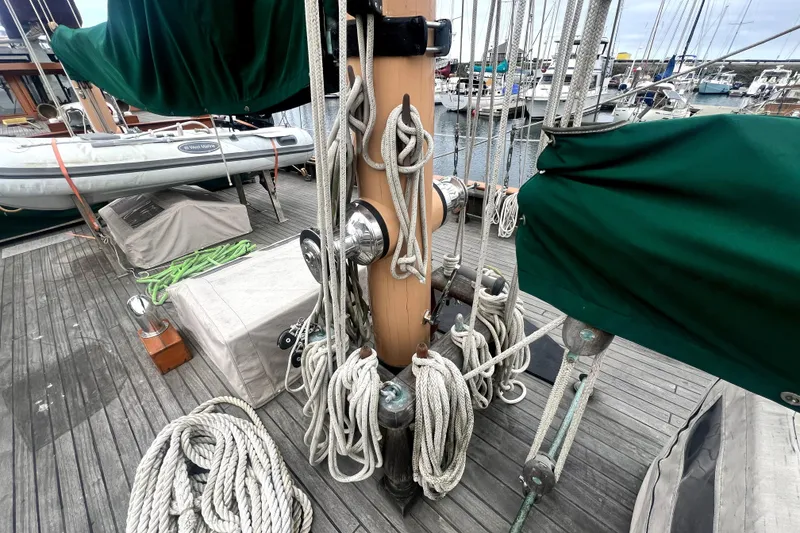 Slide: The Image of Deck of 1934 Pankey Schooner with ropes, mast, and covered equipment in a marina. - 19