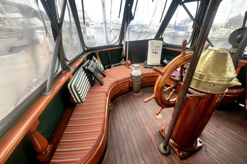 Slide: The Image of Interior of 1934 Pankey Schooner with wooden helm and striped seating. - 22