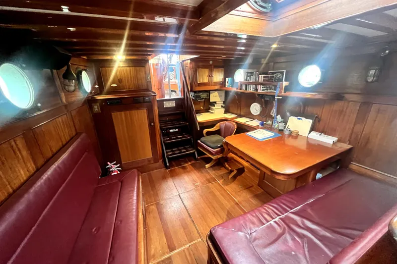 Slide: The Image of Interior of 1934 Pankey Schooner with wooden furnishings and maroon seating. - 34