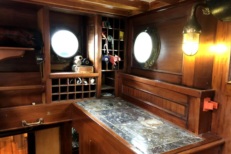 Slide: The Image of Interior of 1934 Pankey Schooner with wooden cabinetry and porthole windows. - 35