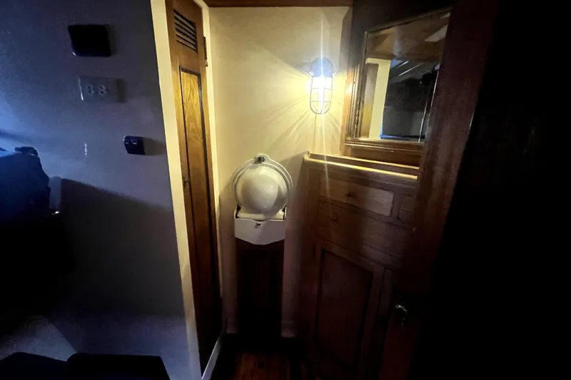 Slide: The Image of Interior of 1934 Pankey Schooner with wooden cabinetry and nautical lighting. - 43