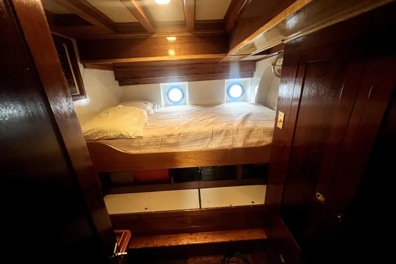 Slide: The Image of Cozy cabin interior of 1934 Pankey Schooner with wooden bed and porthole windows. - 46