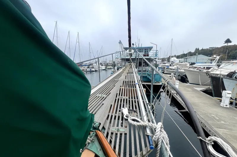 Slide: The Image of 1934 Pankey Schooner docked at a marina, surrounded by other boats. - 7