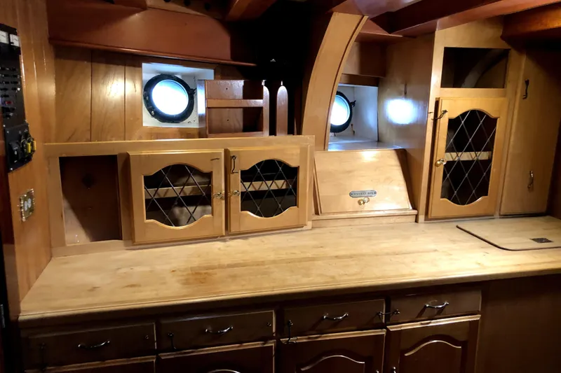 Slide: The Image of Interior of 1934 Pankey Schooner with wooden cabinets and porthole windows. - 70