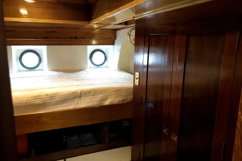 Slide: The Image of Cozy cabin interior of 1934 Pankey Schooner with wooden furnishings and porthole windows. - 72
