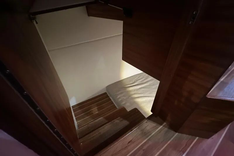 Slide: The Image of Interior stairs of 2026 Ocean Sport 33 Cummins Shaft Drive boat, featuring wooden finish. - 11