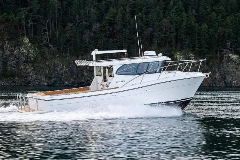 Slide: The Image of 2026 Ocean Sport 33 Cummins Shaft Drive boat on calm water. - 2