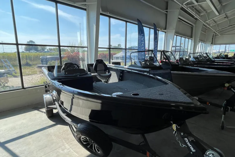 Slide: The Image of 2026 Crestliner 1650 Fish Hawk SC boat displayed in a showroom with large windows. - 17