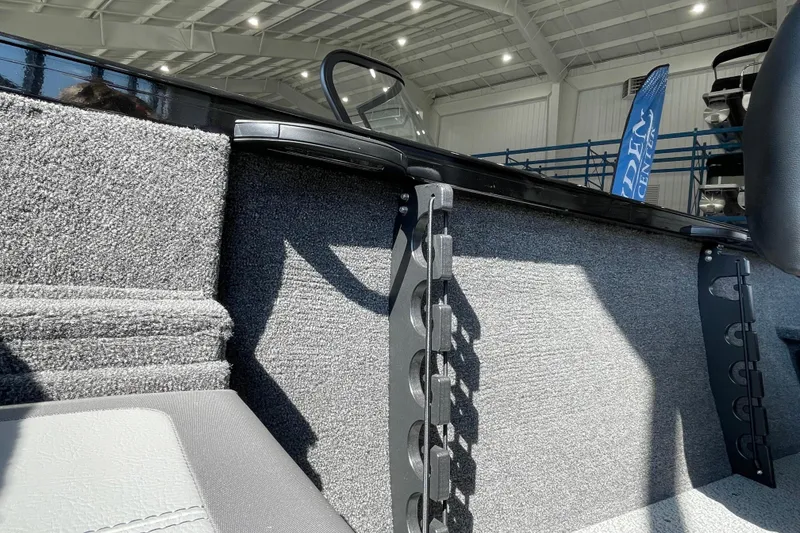 Slide: The Image of 2026 Crestliner 1650 Fish Hawk SC interior detail with rod holders and carpeted finish. - 5