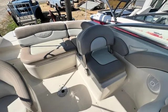 Slide: The Image of 2004 Sea Ray 220 Sundeck interior with cushioned seating and steering area. - 5
