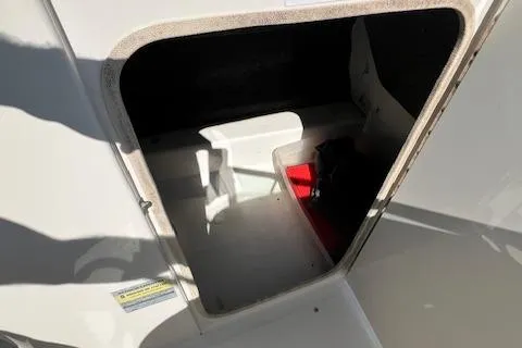 Slide: The Image of 2004 Sea Ray 220 Sundeck storage compartment with open hatch, showing interior space. - 7