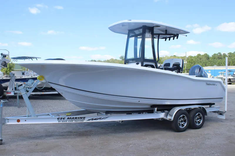 Slide: The Image of 2026 Tidewater 220 CC Adventure boat on trailer, parked outdoors under blue sky. - 1
