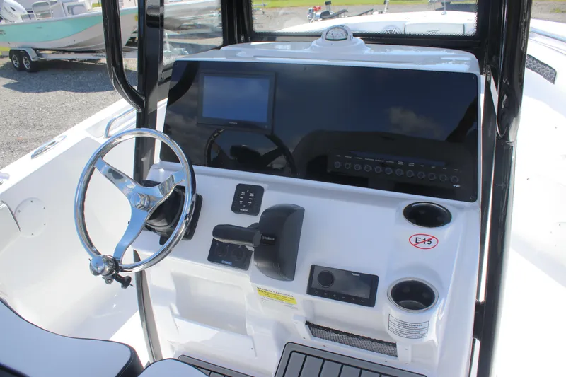Slide: The Image of 2026 Tidewater 220 CC Adventure boat console with steering wheel and control panel. - 14