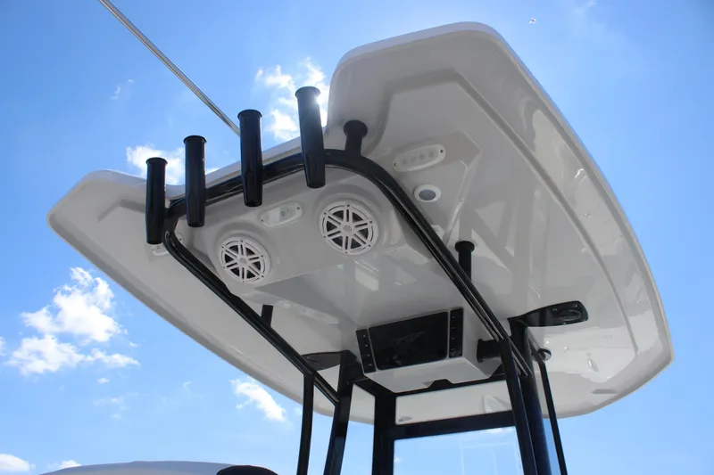 Slide: The Image of Tidewater 220 CC Adventure 2026 boat T-top with speakers against blue sky. - 16