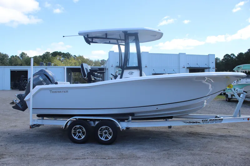 Slide: The Image of 2026 Tidewater 220 CC Adventure boat on trailer, side view, outdoors. - 2