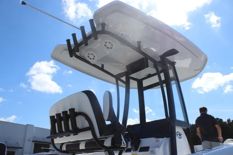 Slide: The Image of 2026 Tidewater 220 CC Adventure boat with T-top and rod holders under a clear blue sky. - 6
