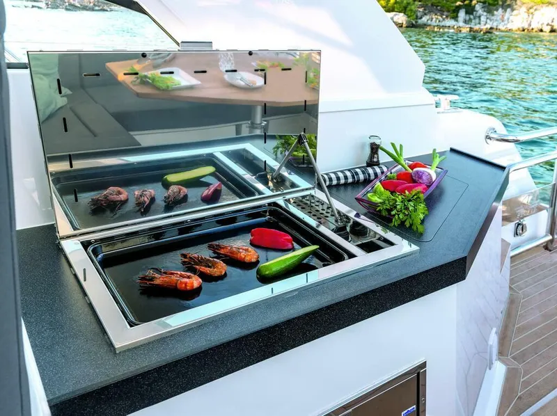 Slide: The Image of Outdoor grill on 2026 Sealine S335V yacht with seafood and vegetables by the water. - 12