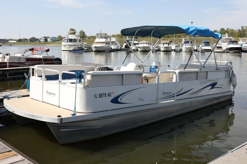 Slide: The Image of 2007 Sundancer Pontoons 24LX with blue canopy docked on calm water. - 5