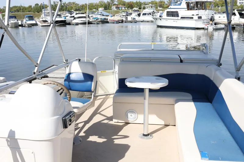 Slide: The Image of 2007 Sundancer Pontoons 24LX interior with seating and table, docked at marina. - 7