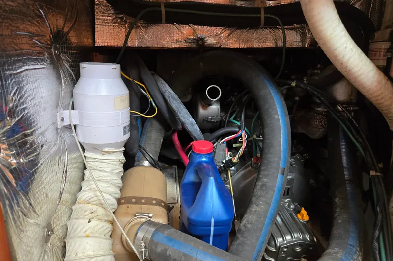 Slide: The Image of Engine compartment of a 1997 Freedom 35 sailboat with hoses and a blue fluid container. - 10