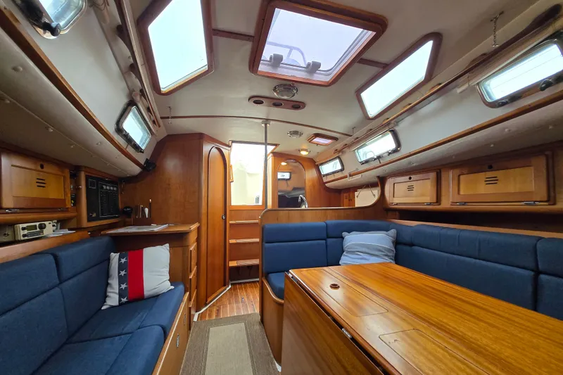 Slide: The Image of Interior of a 1997 Freedom 35 sailboat with wooden furnishings and blue seating. - 11