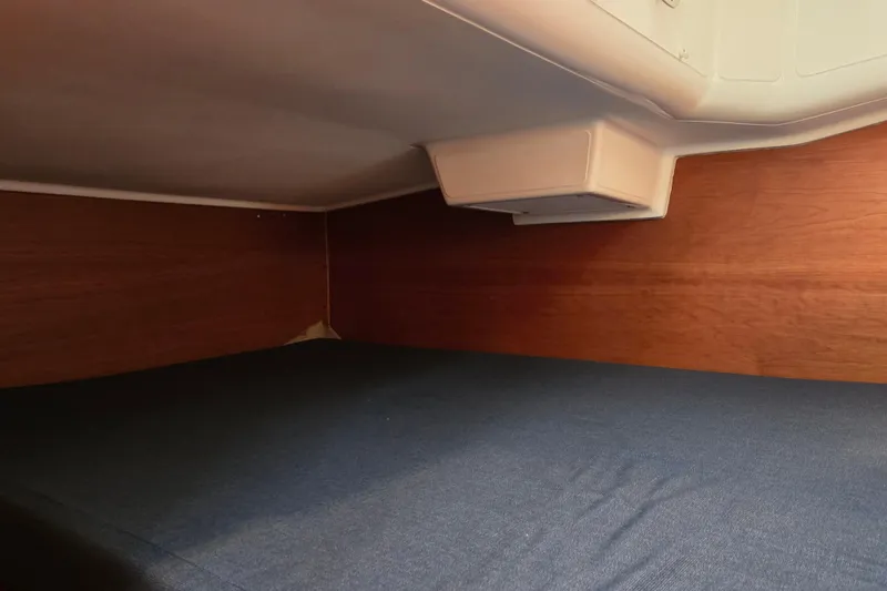 Slide: The Image of 1997 Freedom 35 interior cabin with wooden walls and blue bedding. - 13