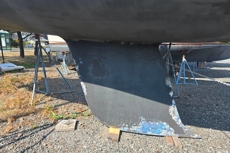 Slide: The Image of 1997 Freedom 35 sailboat keel on stands, showing wear and paint chipping. - 15