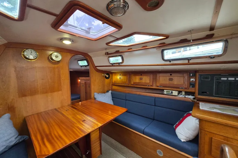 Slide: The Image of Cozy 1997 Freedom 35 yacht interior with wooden finish and blue seating. - 3
