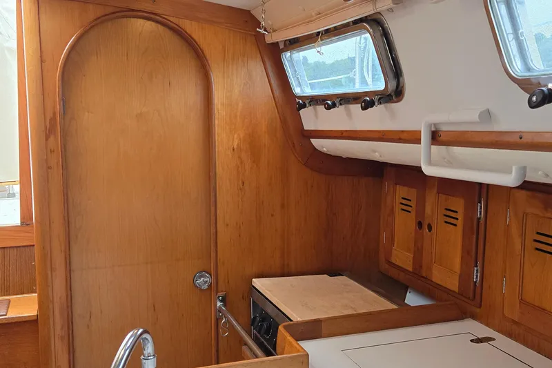 Slide: The Image of Interior of a 1997 Freedom 35 sailboat with wooden cabinetry and porthole windows. - 6