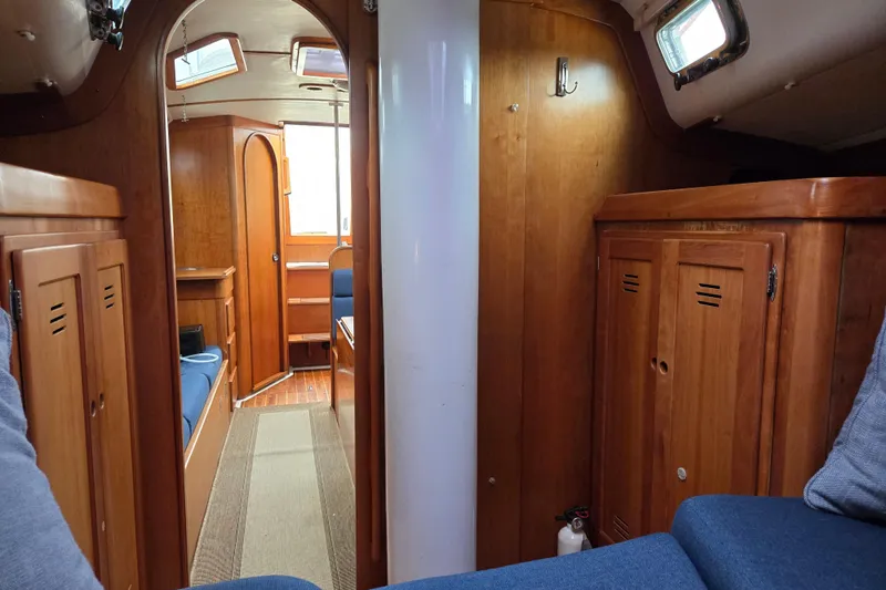Slide: The Image of Interior of a 1997 Freedom 35 sailboat with wooden cabinetry and blue seating. - 8
