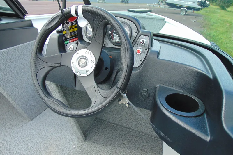 Slide: The Image of Steering wheel and dashboard of 2026 Crestliner 1650 Kodiak boat, featuring gauges and controls. - 11