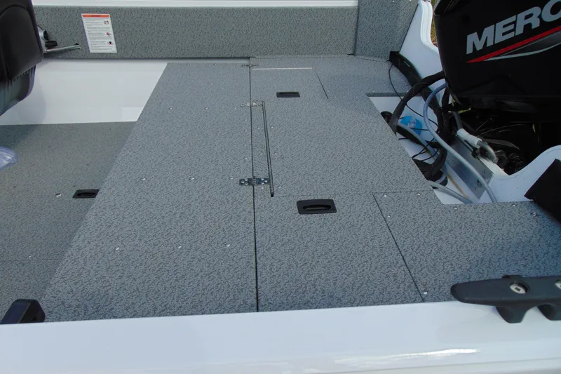 Slide: The Image of 2026 Crestliner 1650 Kodiak boat interior with textured flooring and Mercury engine. - 13