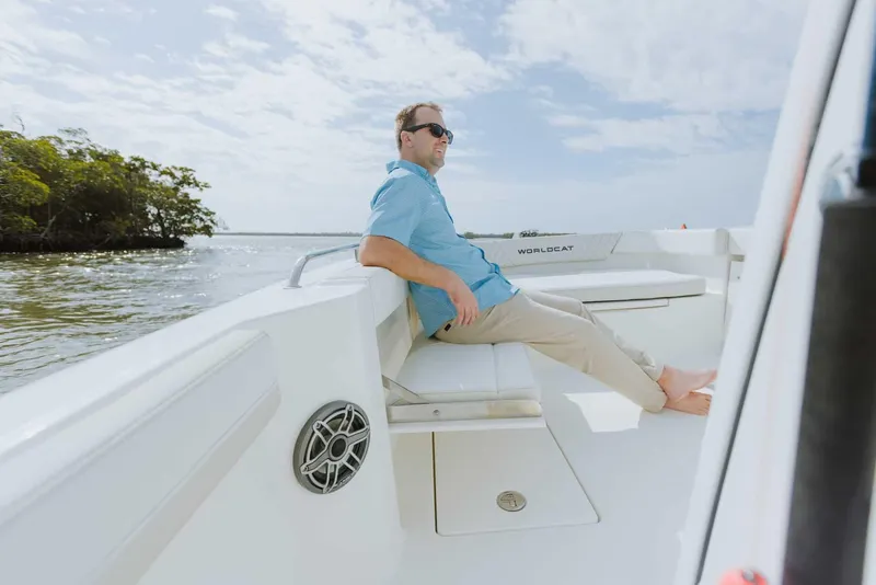 Slide: The Image of Man relaxing on a 2026 World Cat 235TE boat, enjoying a sunny day on the water. - 26