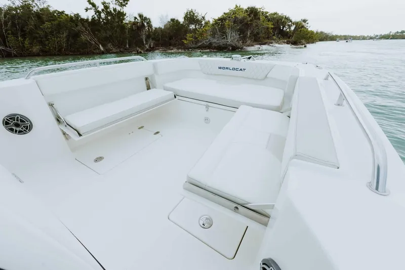 Slide: The Image of 2026 World Cat 235TE boat interior with spacious seating, set against a scenic water backdrop. - 36