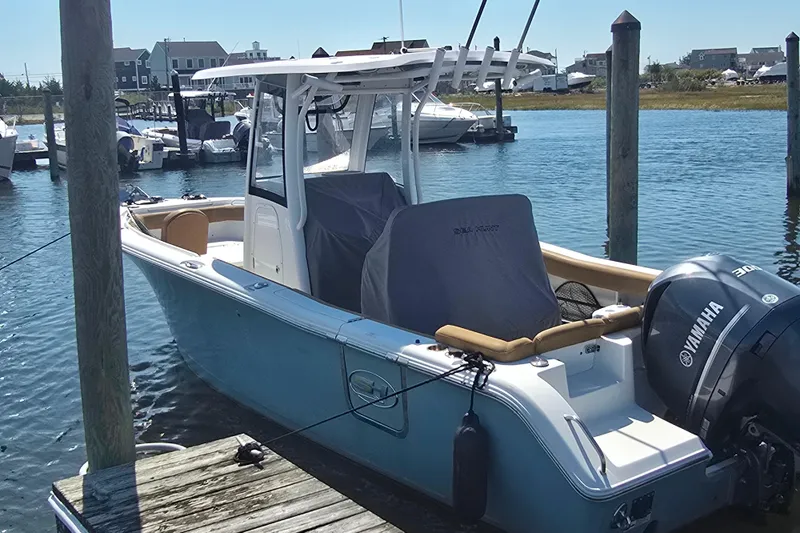 Slide: The Image of 2019 Sea Hunt Ultra 255 SE boat docked in a marina with Yamaha engine. - 1