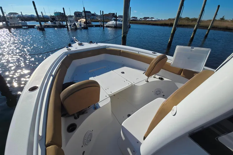 Slide: The Image of 2019 Sea Hunt Ultra 255 SE boat interior with seating, docked at marina. - 16