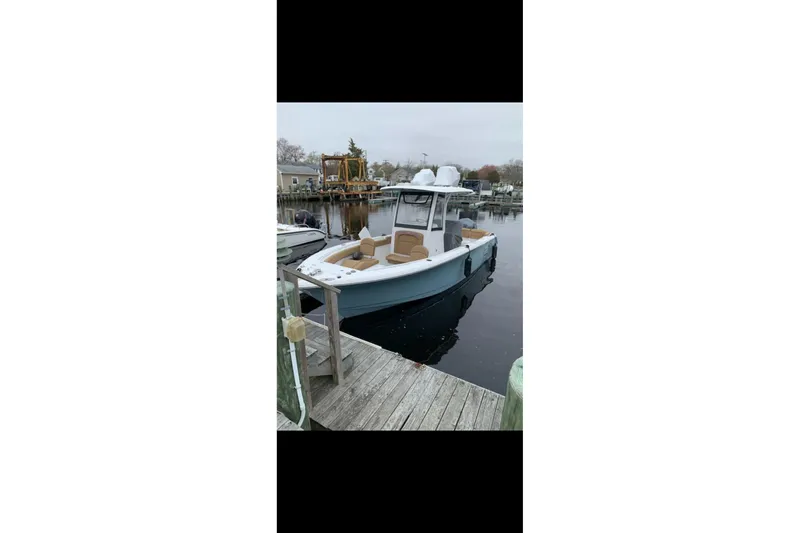 Slide: The Image of 2019 Sea Hunt Ultra 255 SE boat docked at marina, rear view. - 3