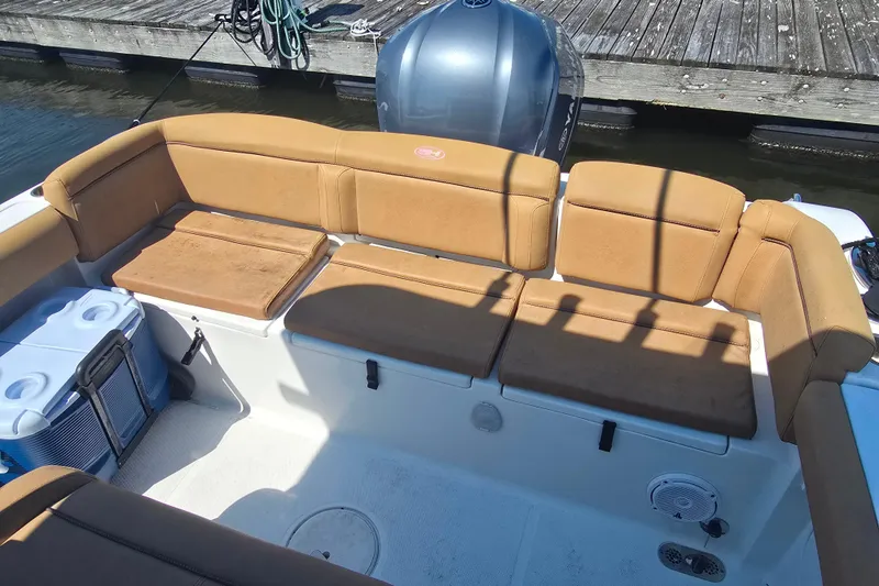 Slide: The Image of 2019 Sea Hunt Ultra 255 SE boat interior with tan seating and fishing gear. - 5