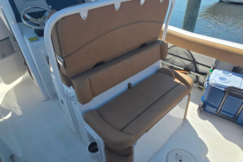 Slide: The Image of 2019 Sea Hunt Ultra 255 SE boat interior with tan seating, docked at marina. - 7