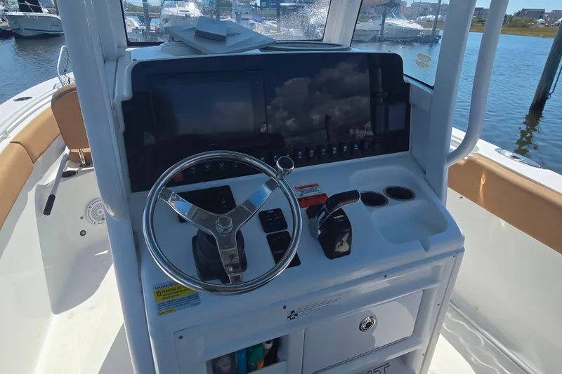 Slide: The Image of 2019 Sea Hunt Ultra 255 SE boat docked at a marina, featuring tan seating. - 8