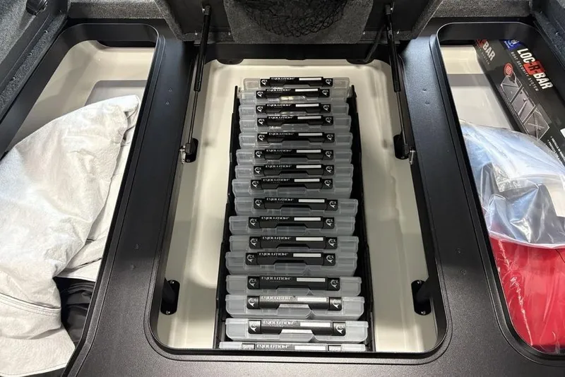 Slide: The Image of Storage compartment in 2026 Skeeter FXR20 Apex boat, organized with tackle boxes and gear. - 12