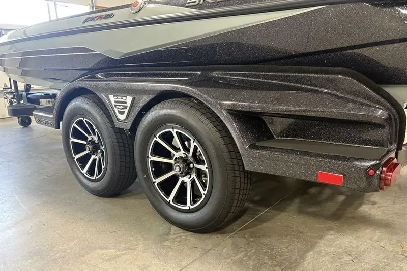 Slide: The Image of 2026 Skeeter FXR20 Apex boat trailer with dual black alloy wheels. - 5
