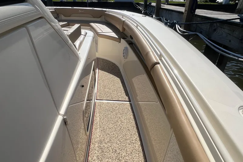 Slide: The Image of 2020 Scout 380 LXF boat interior with beige seating and textured flooring. - 11