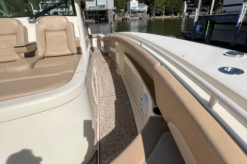 Slide: The Image of 2020 Scout 380 LXF boat interior with beige seating and waterfront view. - 12