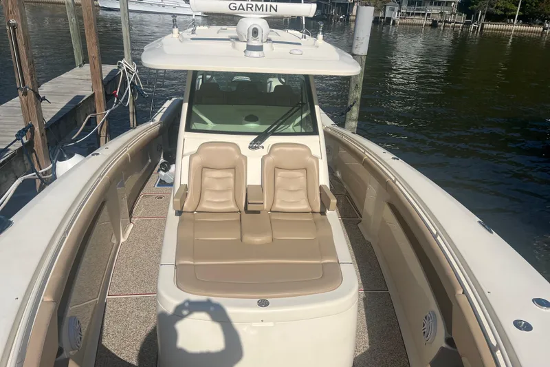 Slide: The Image of 2020 Scout 380 LXF boat with tan seating, docked by the water. - 15
