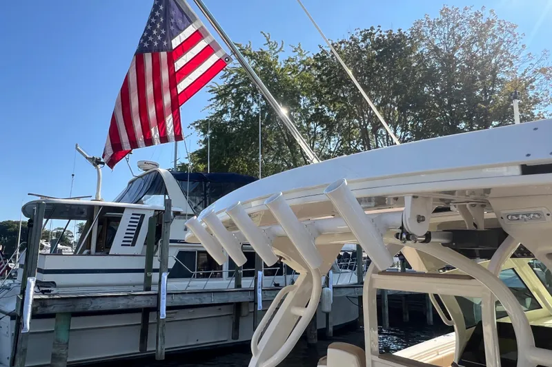 Slide: The Image of 2020 Scout 380 LXF boat docked with American flag, sunny day, marina setting. - 18