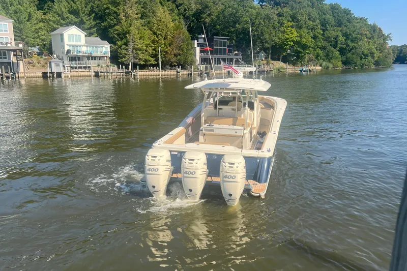 Slide: The Image of 2020 Scout 380 LXF boat with triple 400 engines on a scenic river. - 2