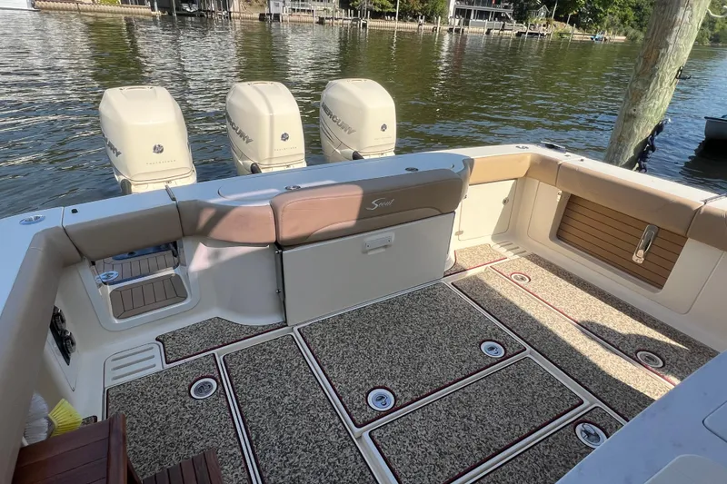 Slide: The Image of 2020 Scout 380 LXF boat interior with triple Mercury engines, docked on a sunny day. - 38